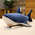 Peluche Requin Cartoon bleu sur un lit